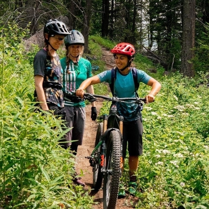 Audrey taking two students mountain biking on the forest trails