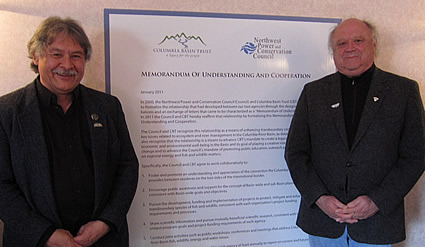 Photo of Garry Merkel and Bruce Measure standing next to the Memorandum of Understanding