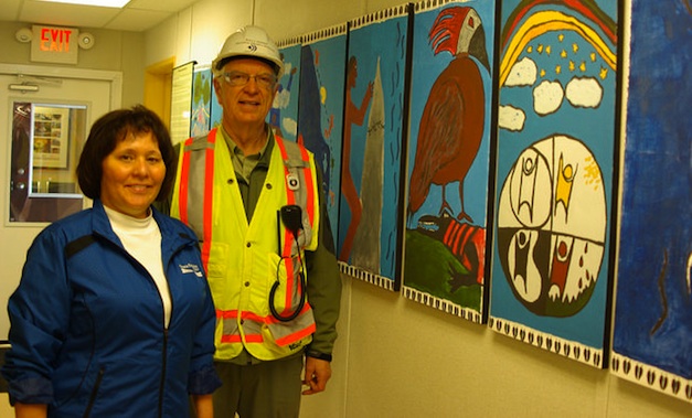 Marion Eunson (left) and Wally Penner, the regional project manager for SNC-Lavalin, show off an artistic depiction of the Ktunaxa creation story.