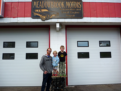 man standing with his kids beside Meadowbrook motors in Kimberley BC