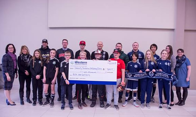 Group shot of donors, holding large cheque. 