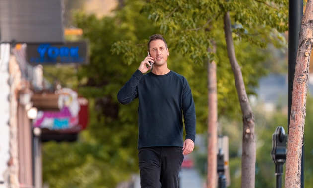 Andrew walking down the street talking on his phone