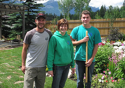 Photo of three people standing outside in a garden