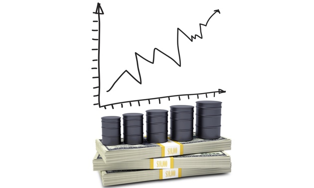 A graph is showing above oil barrels sitting on a stack of money.