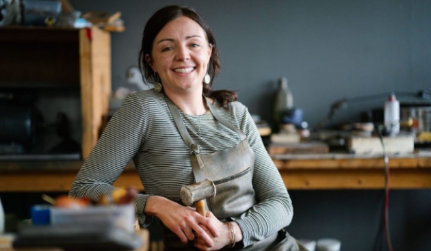 Kat Cadegan sitting in her jewellery making shop