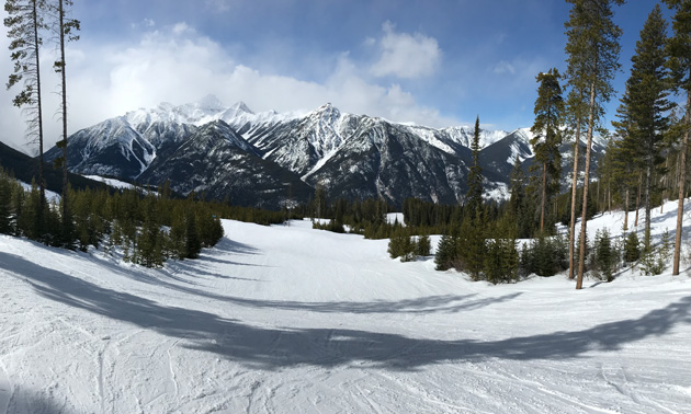 Panoramic view at Panorama Mountain Resort, showing mountains in background, blue sky. 