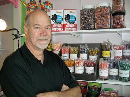 man standing beside a shelf of sweets