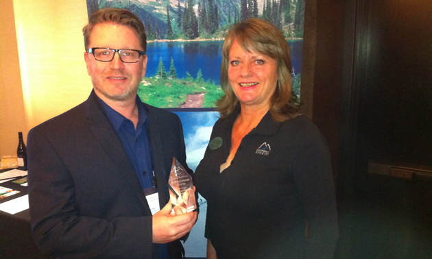 Wendy Van Puymbroeck of Kootenay Rockies presents the best marketing campaign of the year to Ian Thorley of Bellstar Hotels and Resorts.