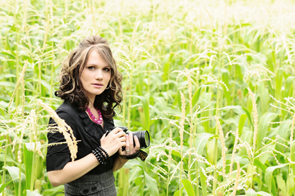 Natalie standing in a field with her camera.