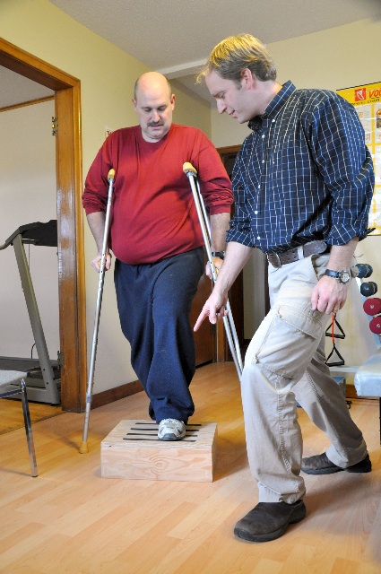 Doctor pointing at man on crutches