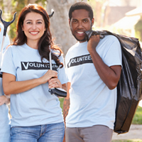 A diverse group of four girls and two guys smiles for the camera holding pick-up tools and garbage bags. They all wear light-blue 