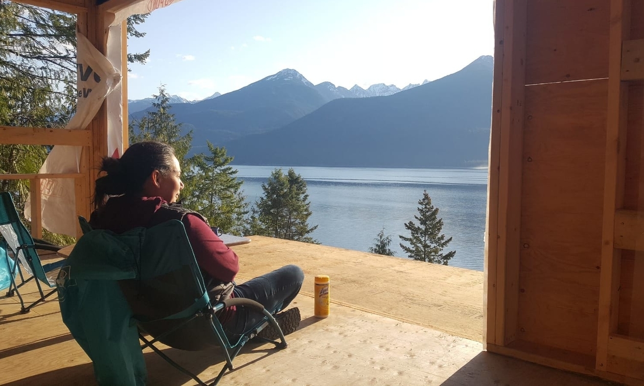 Pilar sitting on a deck looking out at the lake