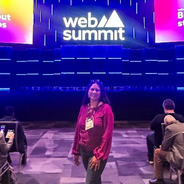 Priya standing on a stage that says Web Summit