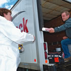 Photo of Dean Kroeker handing a can of spray product to a lady.