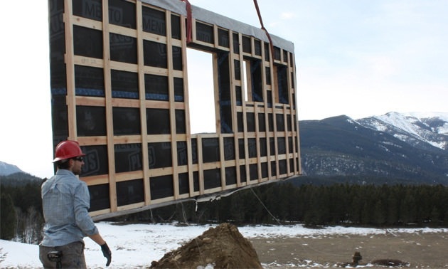 Rane Wardwell oversees the lifting of a panel for a prefab home.