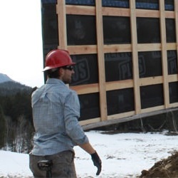 Rane Wardwell oversees the lifting of a panel for a prefab home.