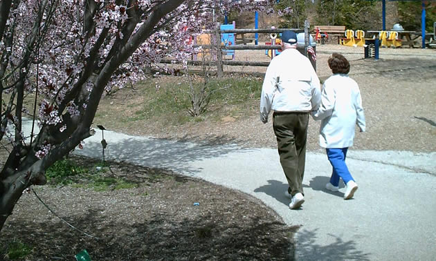 two people walking in a park