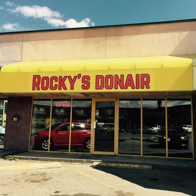 A picture of the outside of the new restaurant in Cranbrook, which shows their yellow awning and the words 'Rocky's Donair' in red. 