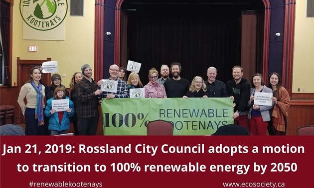 A group of Rossland citizens hold up signs in support of the 100% Renewable Kootenays campaign.