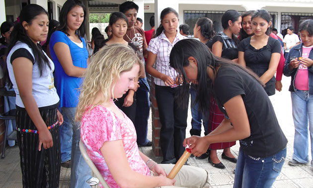 Photo of a student nurse demonstrating how to use condoms for the Sipikapense Indigenous group