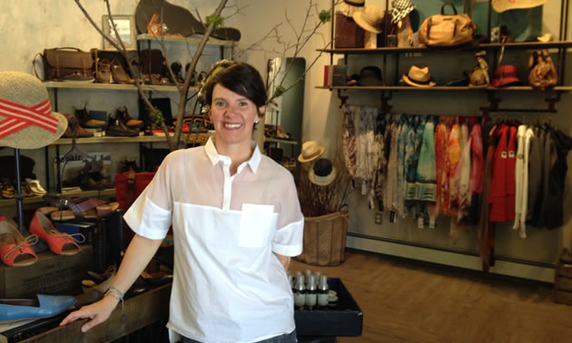 Celeste Needham stands in front of her store's displays of shoes, handbags, scarves and hats.