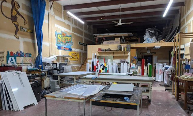 Interior view of sign business with equipment sitting on table. 