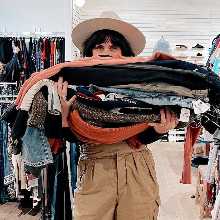 woman holding a pile of clothes