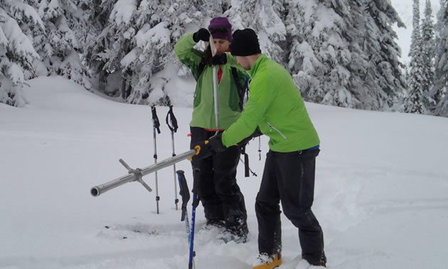 Volunteers with the North Kootenay Lake Water Monitoring Program measure the snowpack. 