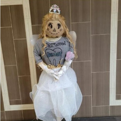 Tooth fairy scarecrow wearing grey t-shirt, white skirt and tiara. 