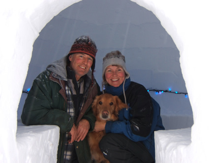 Charlie Sims, Sunny the dog and  Martina Danzer sitting in an igloo