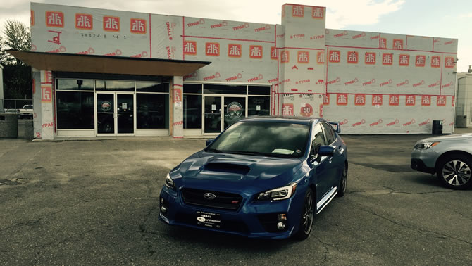 Picture of car parked in front of building being renovated. 