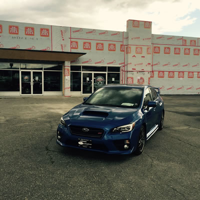 Picture of car parked in front of building being renovated. 