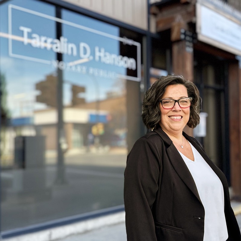 Tarralin D. Hanson, wearing a dark blazer and white blouse standing in front of her business
