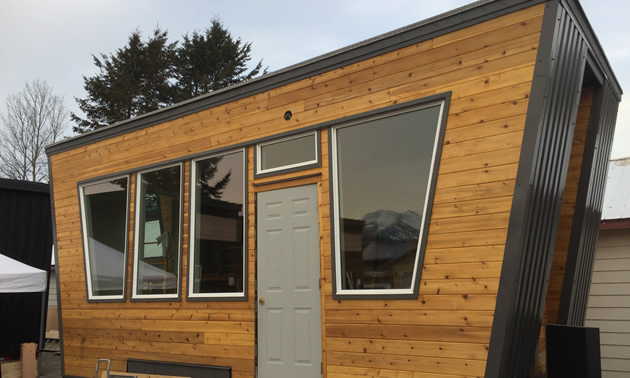 A picture of a tiny home with cedar siding. 