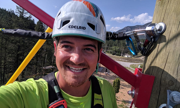 Patrick Tolchard wearing a helmet going ziplining