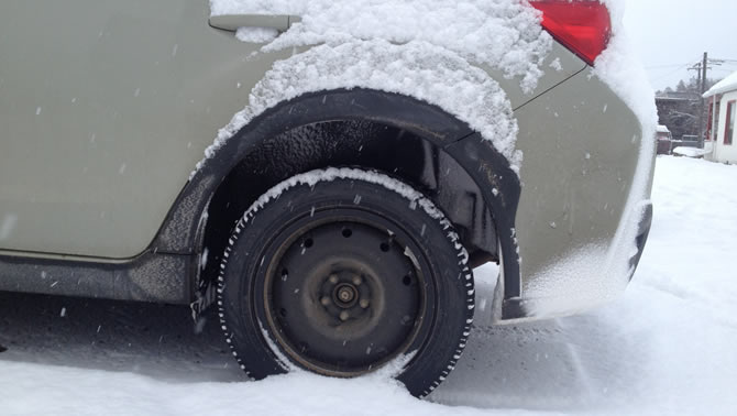 An Observe tire on a Subaru in the snow