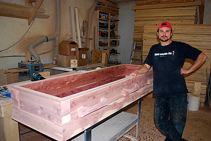 Zeabin standing beside a coffin he has built