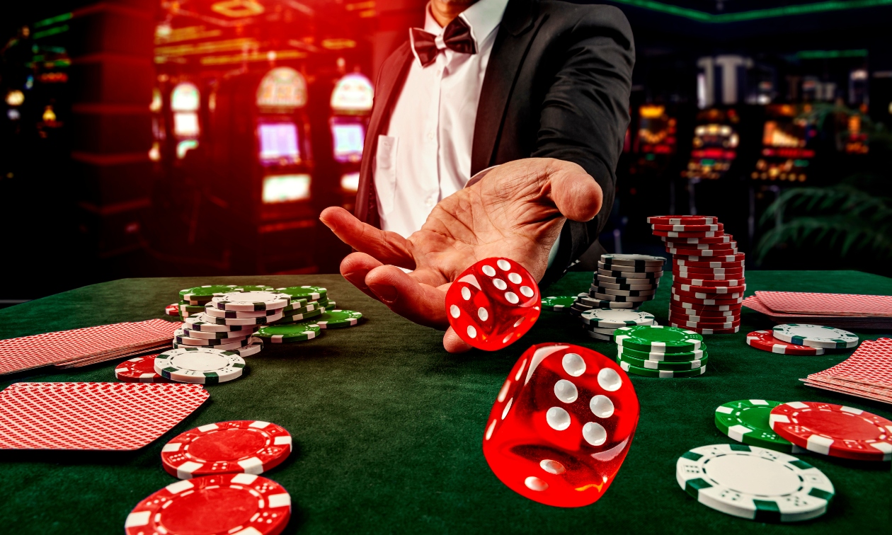 closeup of a hand rolling red and green dice at a casino