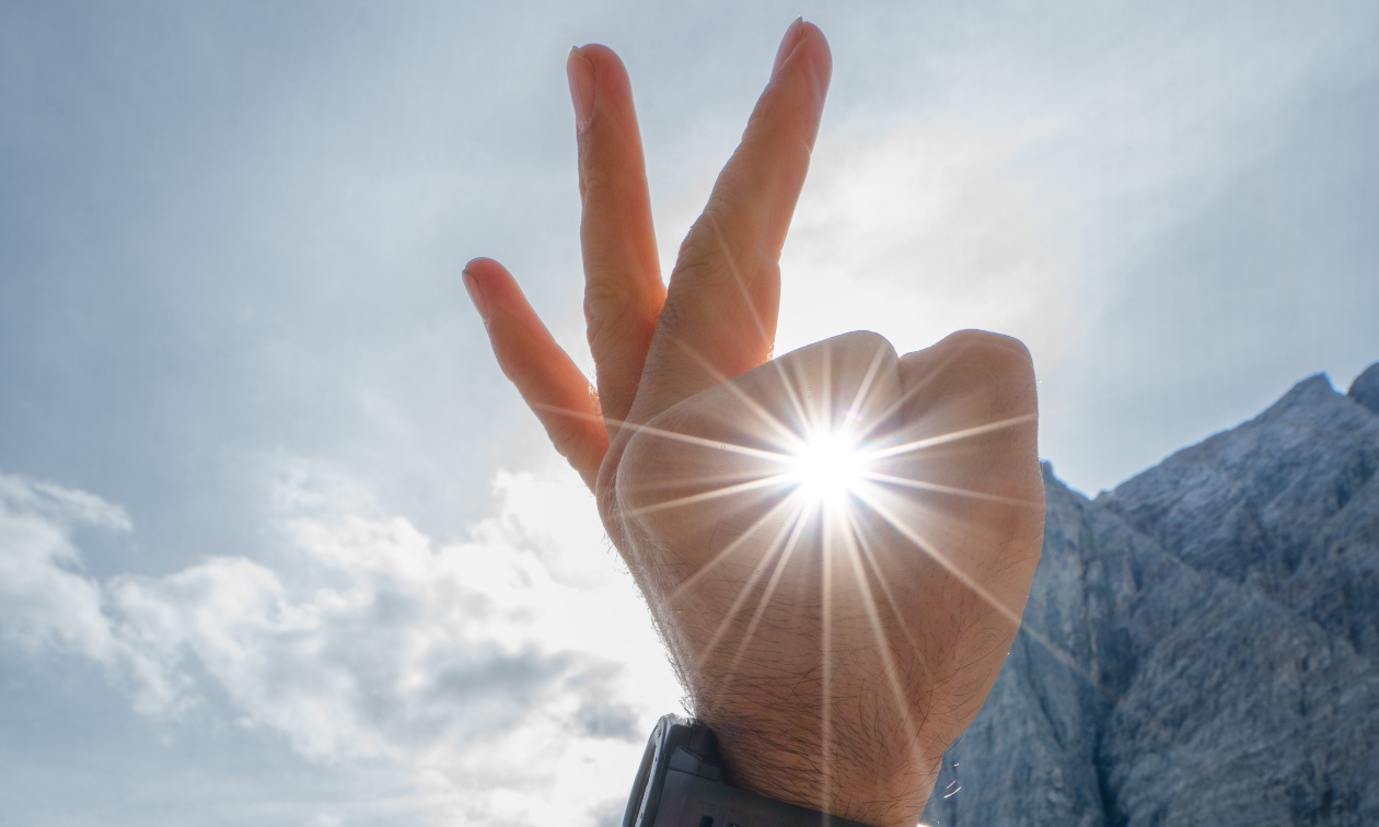 person's hand making an OK sign around the sun