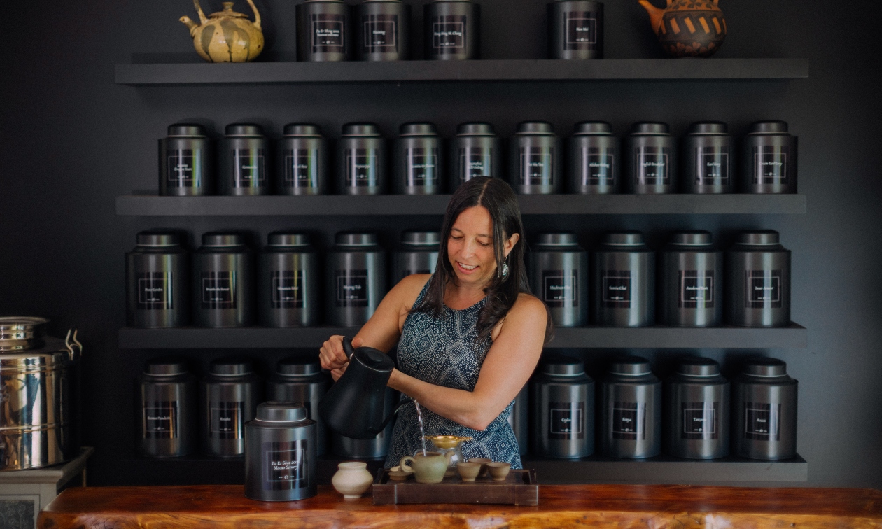 Melanie Pulla of Water Over Leaves in front of her counter