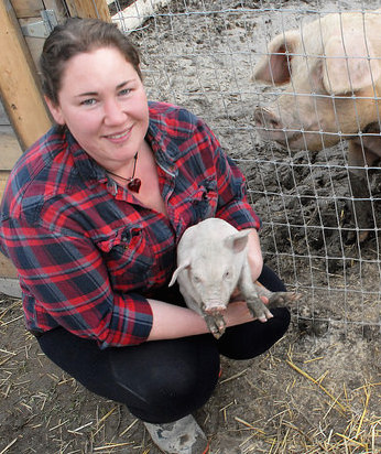 Jessica Piccinin with a piglette born on Root and Vine Acres in the Creston Valley.
