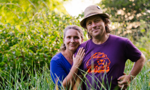 The owners of Track Street Growers standing in a field 